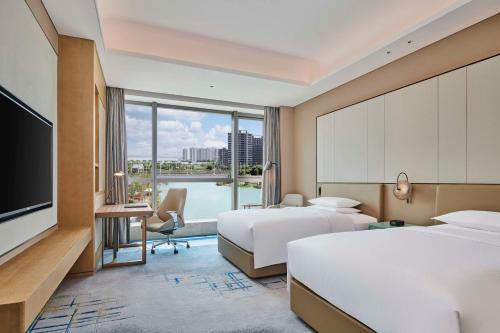 苏州苏州吴中希尔顿逸林酒店的酒店客房设有两张床和电视。
