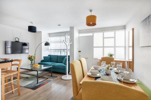 伦敦- Cozy 3 Bed House on a Quiet Mews -的用餐室以及带蓝色沙发的起居室。