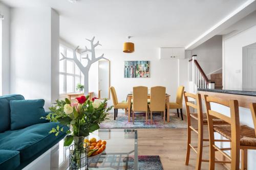 伦敦- Cozy 3 Bed House on a Quiet Mews -的客厅和带蓝色沙发的用餐室