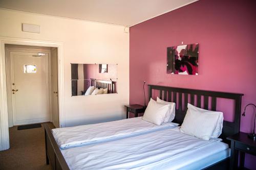 博伦厄Saga Hotell的一间卧室配有一张粉红色墙壁的床