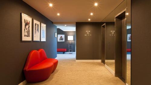 里斯本卢特西亚智能设计酒店的走廊上,房间里摆放着红色椅子