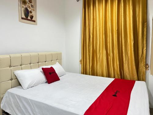 PanikiRedDoorz at Ring Road II Area Manado的一间卧室配有一张床铺,床上铺有红色毯子