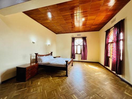 阿鲁沙Mahali Muzuri, Arusha的一间卧室设有一张床和木制天花板