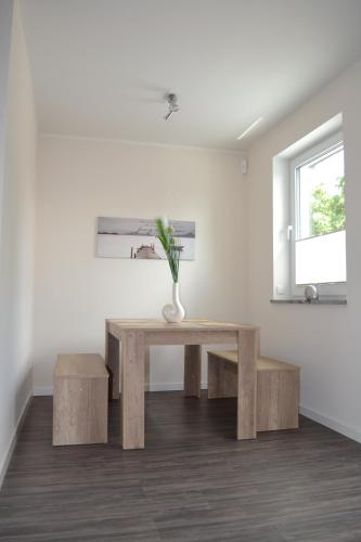 比恩多夫Ostseeoase Kühlungsborn的窗户房间里一张桌子和长凳