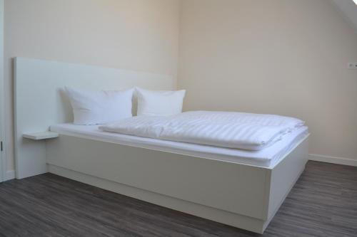 比恩多夫Ostseeoase Kühlungsborn的白色的床、白色床单和枕头