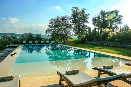 基安蒂格雷夫Villa Rignana - Chianti Weddings的游泳池旁设有躺椅