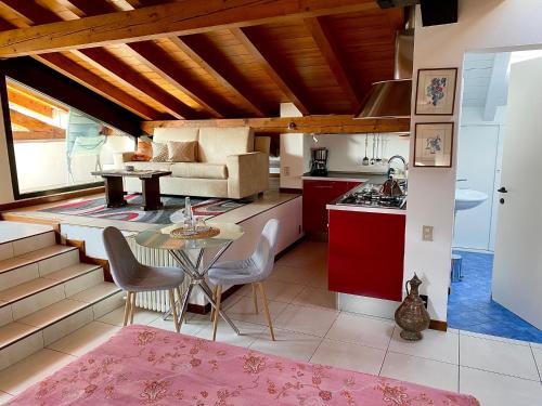 坎诺比奥Villa Costantina with heated POOL的厨房以及带红色橱柜和桌子的客厅。