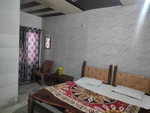 马图拉Hotel Shubhadra Guest House的一间卧室配有一张床和一把椅子