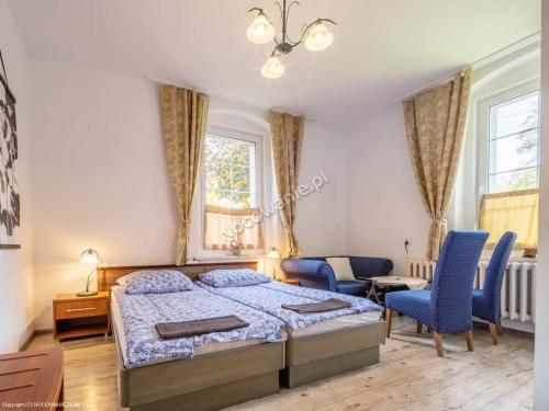库多瓦-兹德鲁伊Willa Dunajec的一间卧室配有一张床和两张蓝色椅子