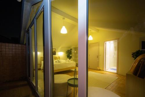 普里什蒂纳Apartments PRN的带一张床的卧室和玻璃门
