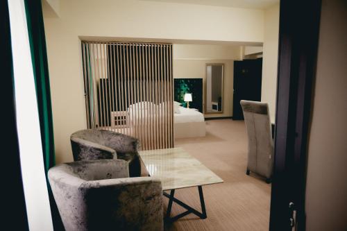 特尔戈维什泰Hotel Valahia的酒店客房带一张床、一张桌子和椅子