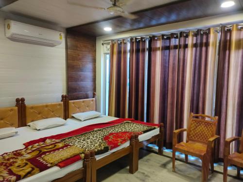 马图拉Hotel Shubhadra Guest House的一间卧室配有一张床、两把椅子和一个窗户