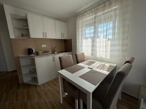 索科矿泉村Villa Ronić的厨房配有白色的桌椅、桌子和窗户。