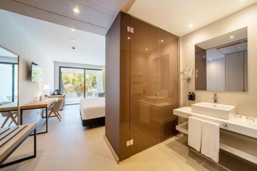 马贝拉Eurostars Oasis Marbella的一间带水槽和淋浴的浴室以及一间卧室