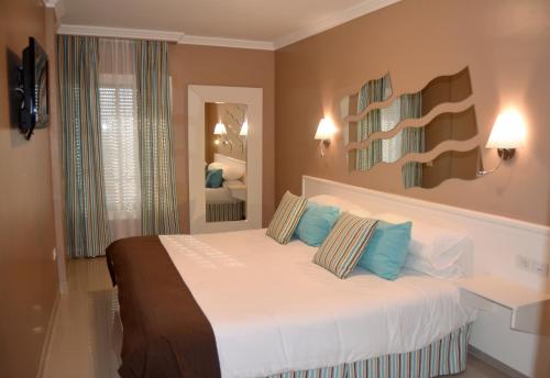 圣乌尔苏拉Residencial La Quinta Park Suites的一间卧室配有一张带蓝色枕头的大床