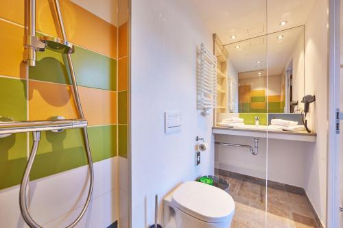 法尔先特Explorer Hotel Garmisch的带淋浴、卫生间和盥洗盆的浴室