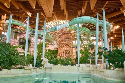 贝利罗曼维利而Center Parcs Villages Nature Paris的一座带游泳池的建筑中的水滑梯