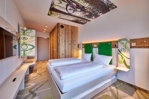 法尔先特Explorer Hotel Garmisch的一间卧室,卧室内配有一张大床