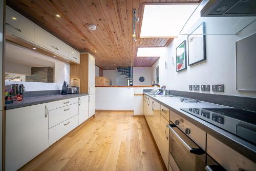 InshKirkstone Lodge的一间设有白色橱柜和木制天花板的大厨房