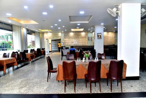 博帕尔Hotel Suraj Palace的一间带长桌和椅子的用餐室