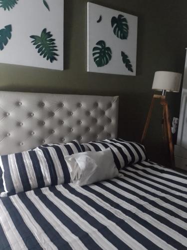 埃塞萨La familia的一间卧室配有一张蓝色和白色条纹的床