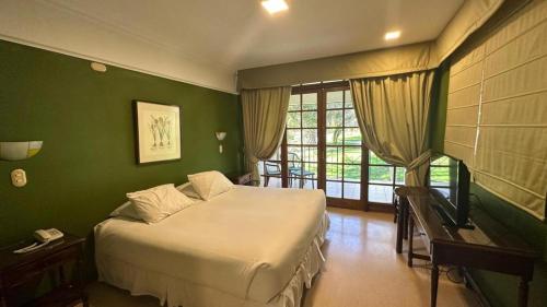埃尔基斯科Hotel y Cabañas Huallilemu Sur - Caja Los Andes的一间卧室设有一张床和绿色的墙壁