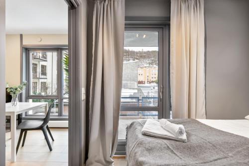 奥斯陆Forenom Serviced Apartments Oslo Munch的一间卧室配有一张床、一张桌子和一个窗户。