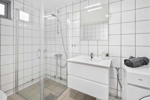 奥斯陆Forenom Serviced Apartments Oslo Munch的带淋浴和盥洗盆的白色浴室