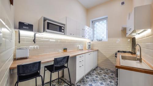 索波特Apartamenty Sun & Snow Lipowa的厨房配有2把吧台凳和水槽