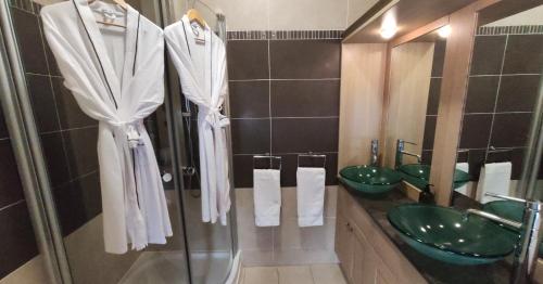 洛赫戈伊尔黑德Lochwood Guest House的一间带两个绿色水槽和淋浴的浴室