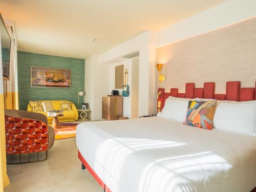 马贝拉Hard Rock Hotel Marbella - Puerto Banús的酒店客房带一张大床和一把椅子