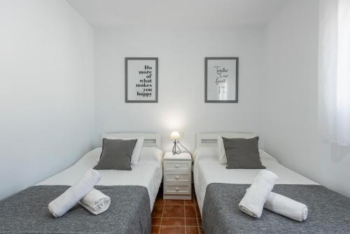 孔佩塔Cortijo Las Vistas的白色墙壁客房中的两张单人床