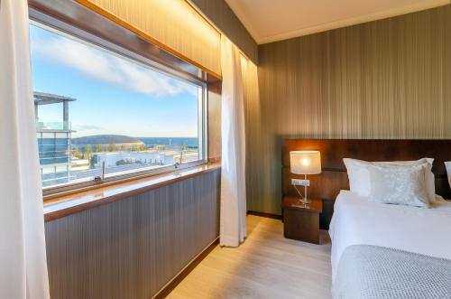 里斯本奥利斯普东方酒店的一间卧室设有一张床和一个大窗户