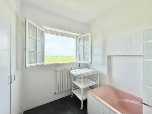 坡隆维茨普尔扎伊LA VILLA STE ANNE - Wifi - Plages et bourg de Plonevez à 2 min的一间带粉色浴缸和窗户的浴室