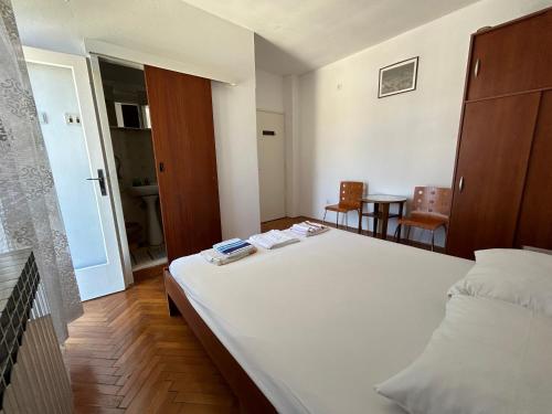 尼亚卢卡Marina的卧室配有一张白色的大床和一张桌子