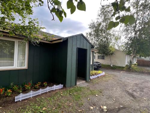 安克雷奇Nunaka Valley Cottage的院子里有门的绿色房子