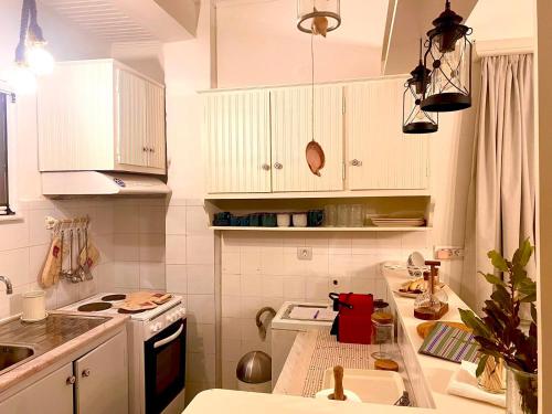 KoríthionCoralina Cottage的厨房配有白色橱柜和炉灶烤箱。