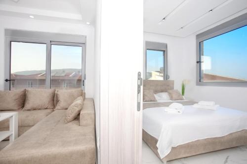 乌尔齐尼NESI Apartments的白色卧室配有床和沙发