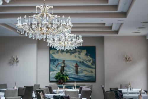 圣安东阿尔贝格珀斯特酒店的一间带桌子和吊灯的用餐室
