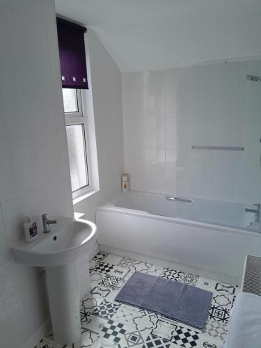 彭布罗克郡Conveniently located, newly refurbished flat (sleeps 4)的白色的浴室设有浴缸和水槽。
