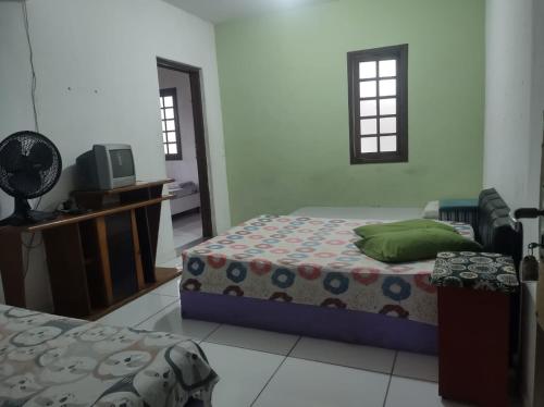 蒙加瓜Pousada em Mongaguá Kali的一间卧室配有两张床和电视。