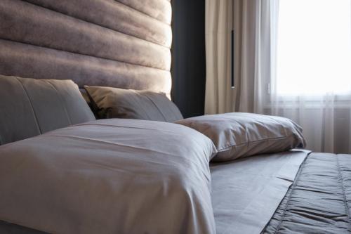 雅典Golden Island Resorts的一张带白色床单和枕头的床,靠窗