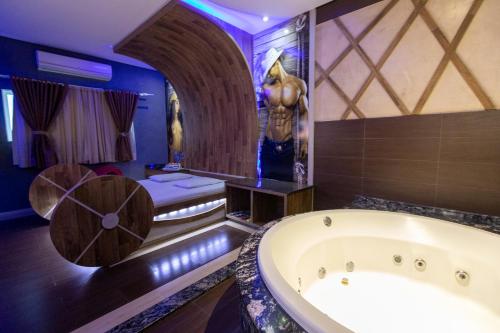 伊瓜苏Troia Motel的一间带浴缸的浴室和一张位于客房内的床