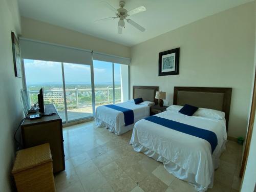 阿卡普尔科Departamento Playa Punta Diamante的酒店客房设有两张床和一个阳台。