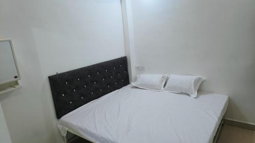 贾巴尔普尔Hotel 100 Meter的一张小床,上面有两个白色枕头