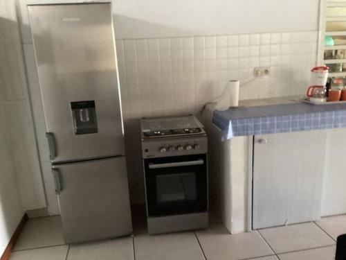 圣贝努瓦Appartement dans propriété reposante的厨房配有不锈钢炉灶和冰箱。
