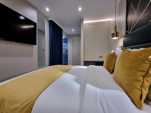 伦敦NOX Kensington Gardens的卧室配有一张带黄色枕头的大型白色床。