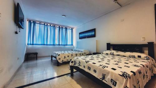 卡塔赫纳Hotel Beijing Cartagena的一间卧室设有两张床和窗户。