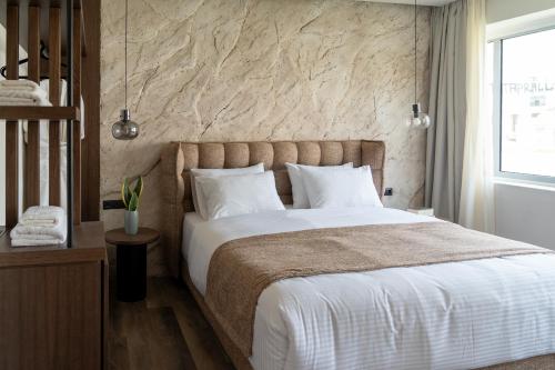 雅典Athens Design Suites的一间卧室设有一张大床和石墙