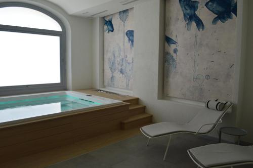 维拉西米乌斯TANIT ROOMS & SPA的一个带窗户和椅子的游泳池